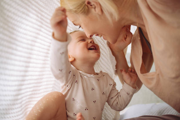 liebende mutter und tochter spielen unter decke - kleinstkind stock-fotos und bilder