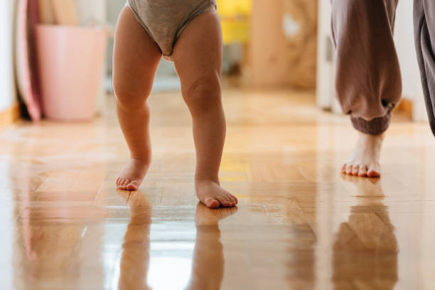 istock Toddler learning to walk with mother at home 1317017389