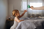 Mother and daughter playing with toy in bedroom