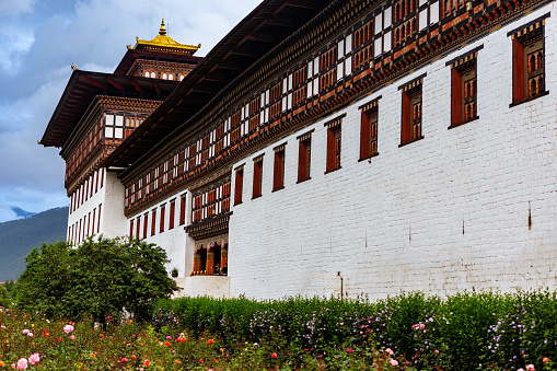 This August 12, 2016 daylight photo shows the exterior of the Tashichho Dzong, the national palace housing Bhutan's royal government. Two guards are visible. The large complex was built as a Buddhist monastery and fortress.