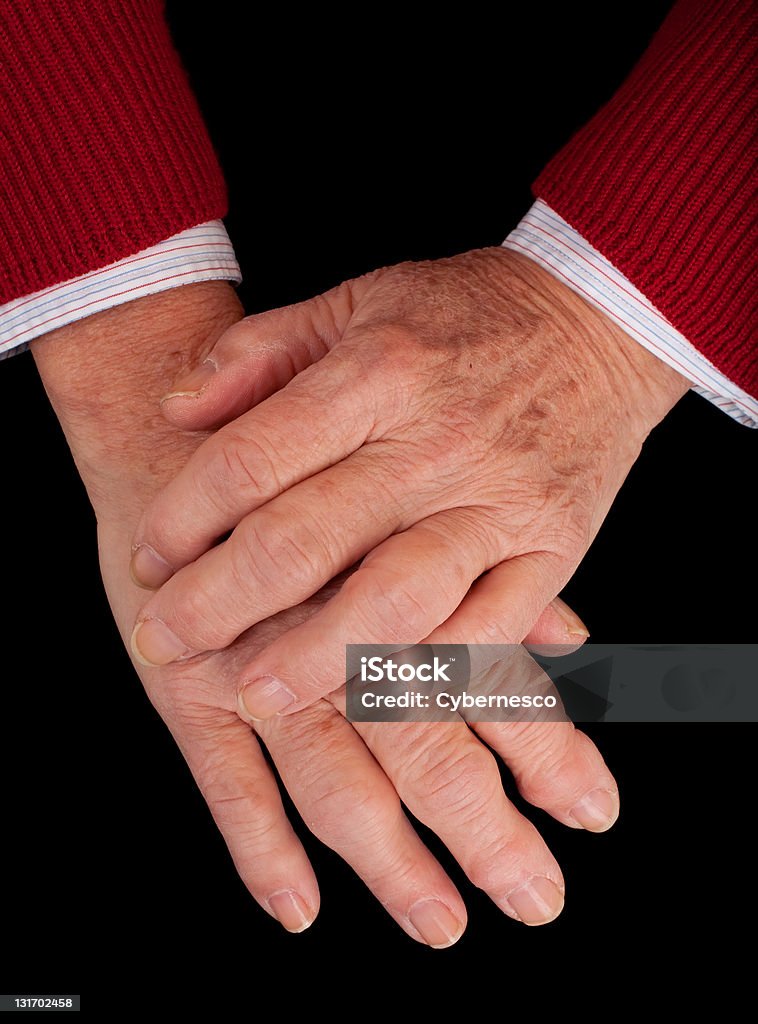 Arthritic Hands Arthritic hands of a senior woman on a black background. Adult Stock Photo