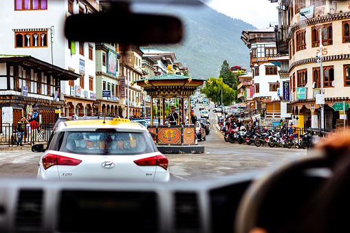 This August 12, 2016 daylight photo shows police officers directing a line of cars at an intersection in Thimphu, the capital city of Bhutan. This photo was taken from a moving vehicle.