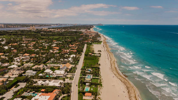 Aerial View of a Vibrant Teal Ocean Seashore Filled with Colorful Beach Umbrellas on Palm Beach, Florida at Mid-Day During COVID-19 in May of 2021 Aerial Overview of a Vibrant Teal Ocean Seashore Filled with Colorful Beach Umbrellas on Palm Beach, Florida at Mid-Day During COVID-19 in May of 2021. florida beach above stock pictures, royalty-free photos & images