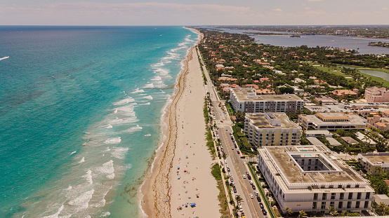Vista aérea de una vibrante costa del océano Teal llena de coloridos sombrillas de playa en Palm Beach, Florida a mediodía durante covid-19 en mayo de 2021 photo