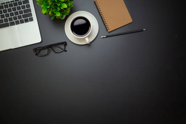 istock Workspace - Flat top view illustration of a workspace with a coffee cup and notebook on the black desk surface,Office desk concept. 1317036172