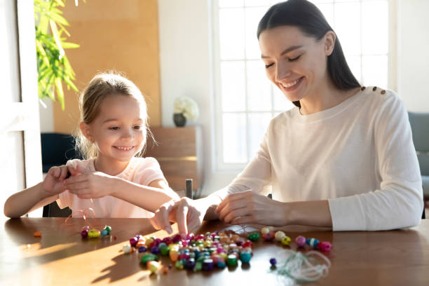 istock Smiling mom and small daughter play at home together 1317036278