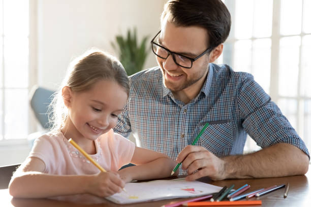istock Caring dad and small daughter drawing in album 1317036284