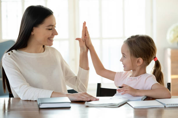istock Happy mom and small daughter finish homework give high five 1317036289