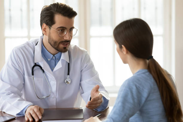 istock Pleasant young handsome male doctor talking to patient. 1317036310