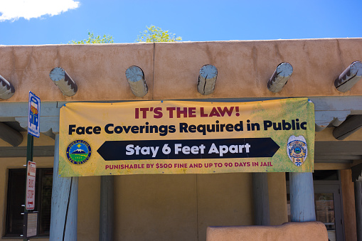 Taos, NM: A banner announcing COVID laws in downtown Taos, including a fine or jail time for non-compliance.