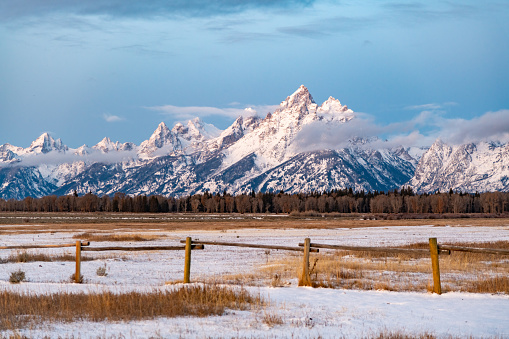 The Tetons just after sunrise in soft clouds after snow fall in late October.