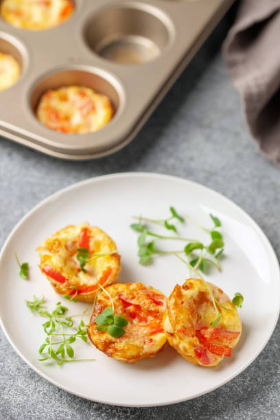 istock Egg muffins  or bites with vegetables and micro greens  in a plate on a gray background 1317042384