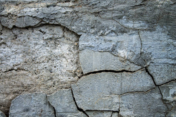 istock Broken wall with cracks. The gray plaster fell off the wall. 1317044050