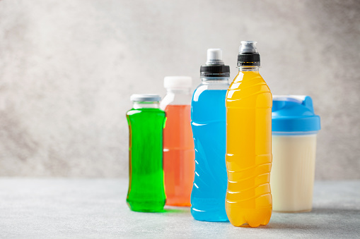 Different sport drinks in bottles - L-carnitine, isotonic and protein shake. Fitness concept.