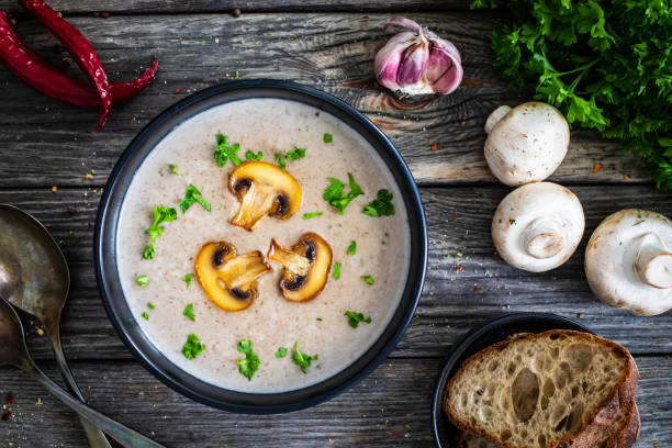 creme weiße pilzsuppe auf holztisch - champignon stock-fotos und bilder