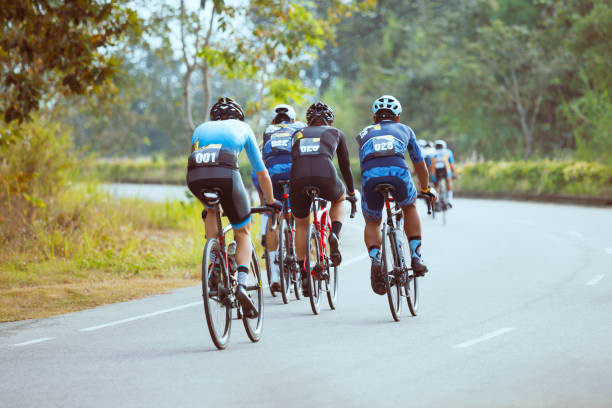 Group of professional cyclists during the cycling race Group of professional cyclists during the cycling race. Shot in back - Image sports race stock pictures, royalty-free photos & images