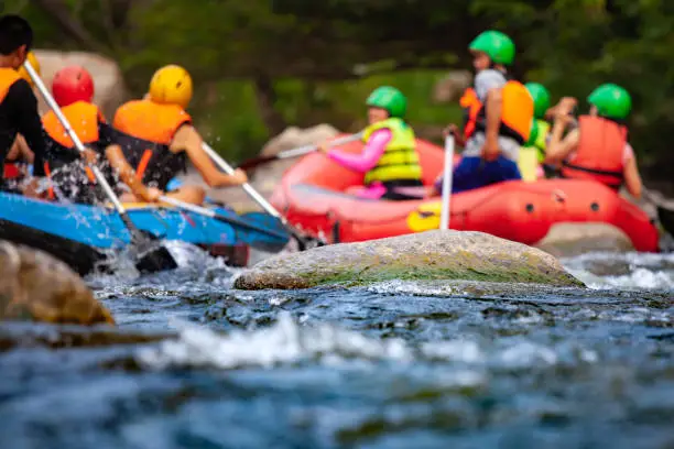 Photo of Close-up of reef with group of young people are rafting