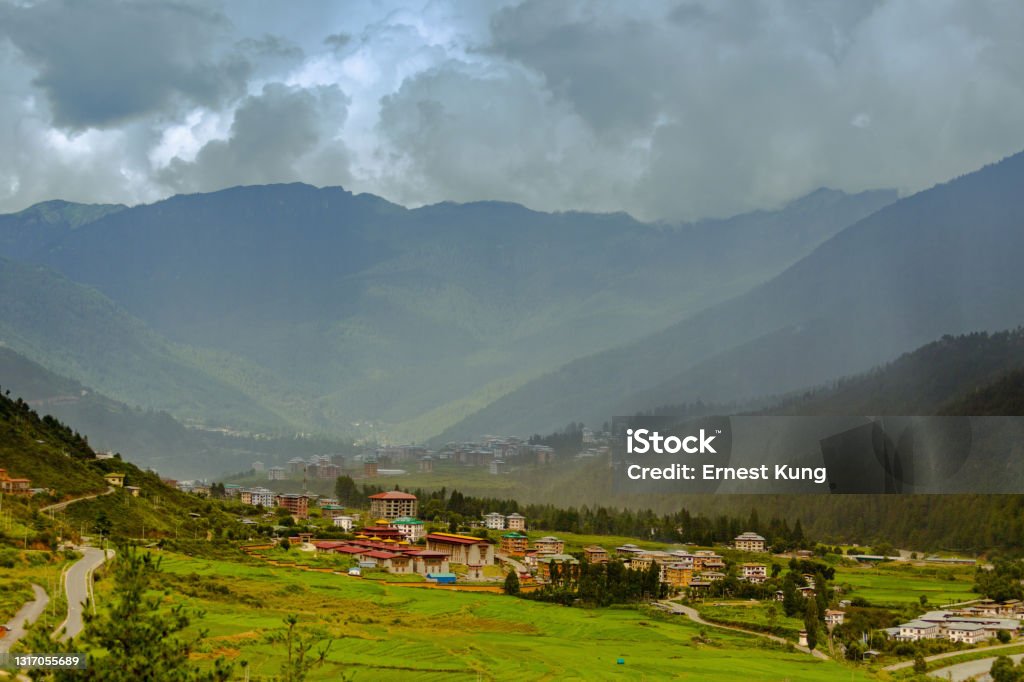 Thimphu, Bhutan, Rain This August 2016 photo shows Thimphu, the capital city of Bhutan. The city is situated in Himalayan valleys. Rain falls in the distance. Asia Stock Photo