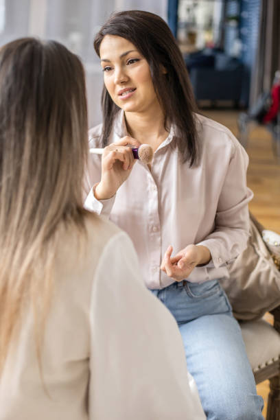 istock Professional female makeup artist applying cosmetics on model face use brush working at beauty salon 1317057170