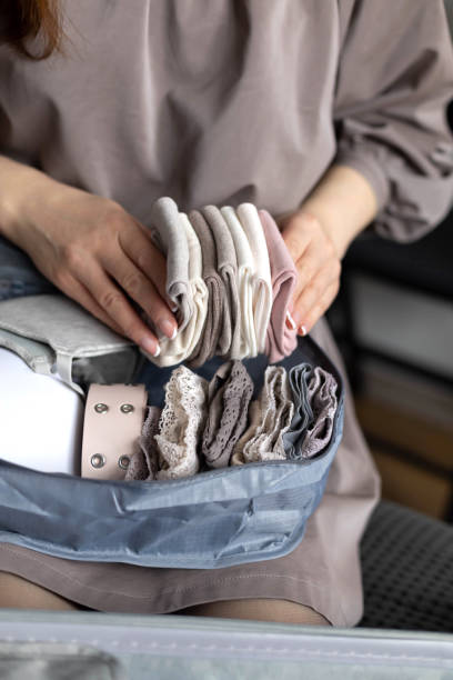 istock Unidentified woman puts lingerie in trip storage container use konmari method packing suitcase 1317065431