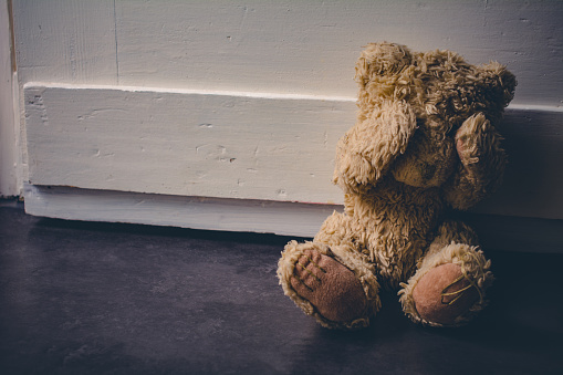 Abandoned Teddy Covering His Eyes, Sitting At Door - Child Abuse Concept