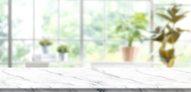 istock Marble table background with blur window see through garden at home.Mockup banner space for product display for advertising at online media 1317072333
