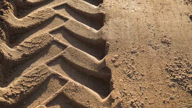 sabbia con battistrada ruota trattore su di esso - caterpillar truck foto e immagini stock