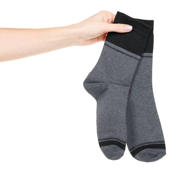 istock Hand with dark cotton socks with pattern isolated on white background 1317075101