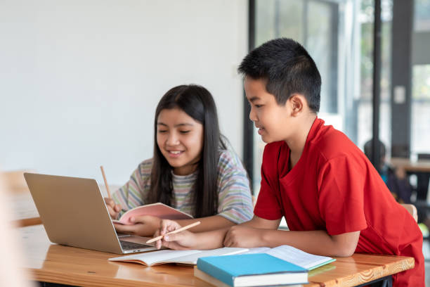 istock Asian man and woman enjoy online learning by taking notes and using laptop at home. 1317075826
