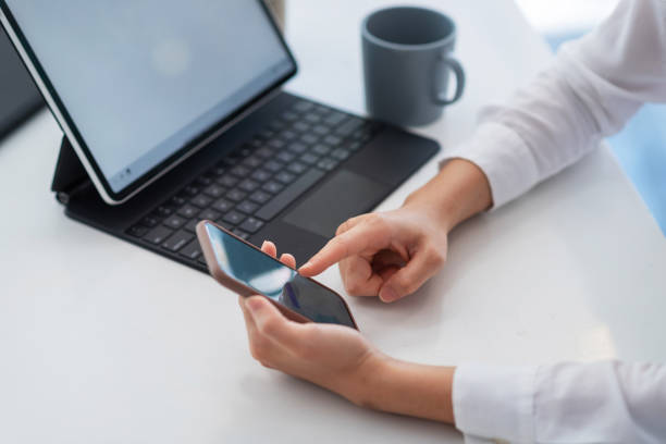 istock Close up of woman hand using mobile phone tablet on table at office. 1317075979