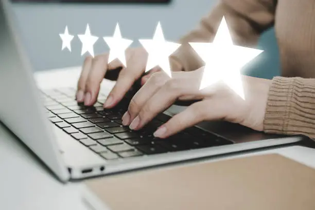 Photo of 5 star rating. business woman hand working on laptop with five star button on visual screen to review good rating, digital marketing, good experience, positive thinking and customer feedback concept