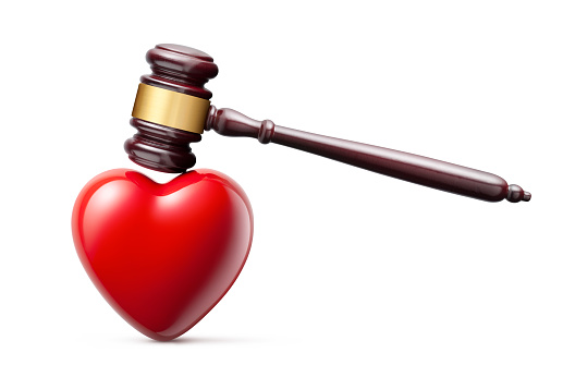 Judge gavel hitting a heart isolated on a white background.