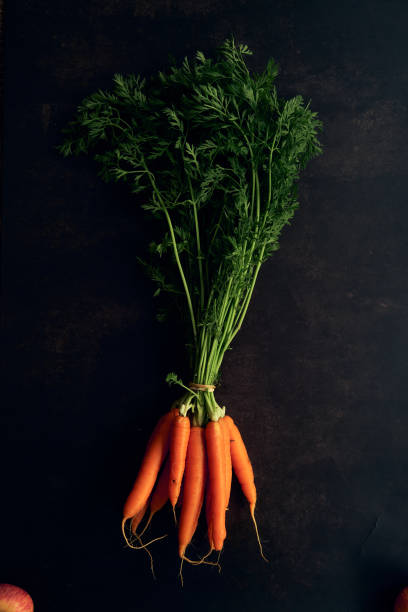 istock clean young carrots on a black background 1317079522