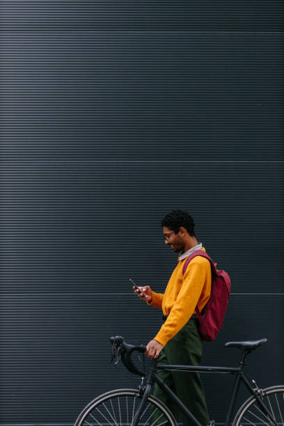 Happy cyclist in the city using phone