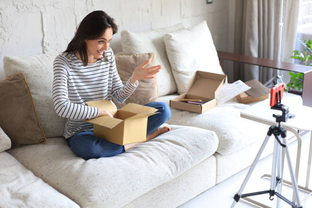 istock Young beautiful female blogger recording video while unpacking parcel at home. 1317080516