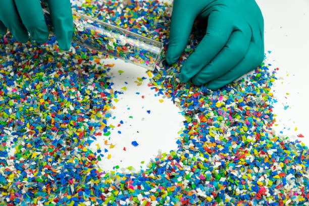 istock Crushed plastic on green gloved hand. Reuse of plastic. polymer beads. Scraps obtained from plastic waste. The world's plastic reduction policy. Scraps plastic on white background. 1317080703