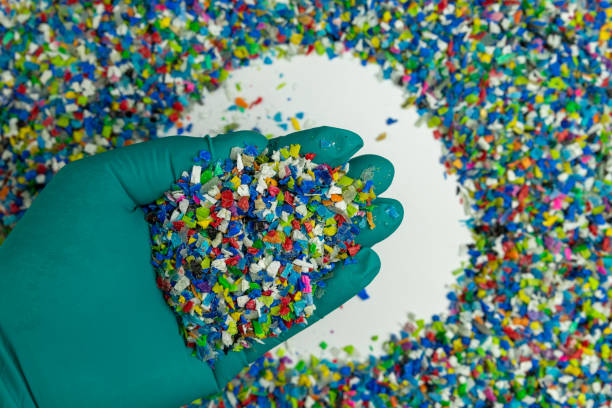 istock Crushed plastic on green gloved hand. Reuse of plastic. polymer beads. Scraps obtained from plastic waste. The world's plastic reduction policy. Scraps plastic on white background. 1317080741