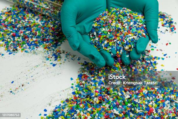 Crushed Plastic On Green Gloved Hand Reuse Of Plastic Polymer Beads Scraps Obtained From Plastic Waste The Worlds Plastic Reduction Policy Scraps Plastic On White Background Stock Photo - Download Image Now