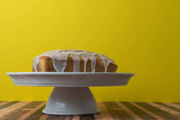 Icing pouring into a lemon drizzle cake stock photo