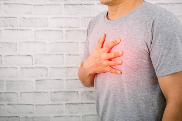 the man holding the chest on the heart heart disease symptoms - chest pain imagens e fotografias de stock
