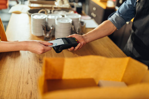 istock Man accepting a digital payment from a customer in a cafe 1317084673