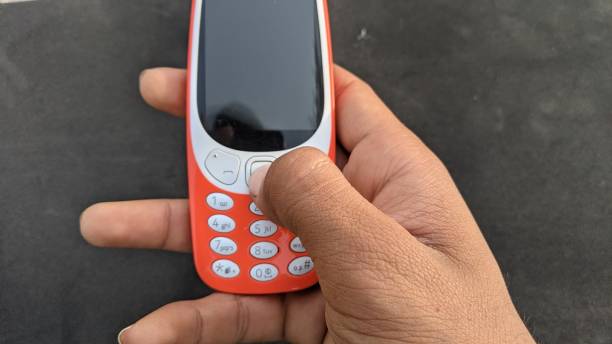 istock Cell phone buttons and black display and keys dialing in hands. 1317088065