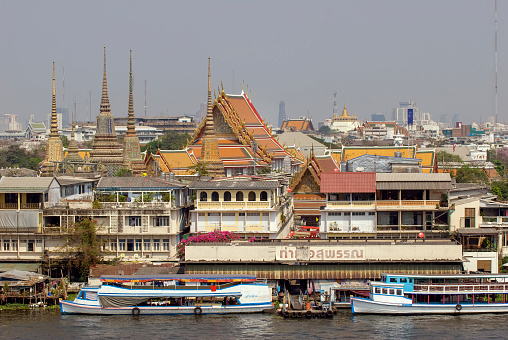 bangkok thailand - february  - 7 - 2009   photographed from wat arun temple and views of temple and boat harbor in bangkok plus boating and water taxi activity along the canals and chao phraya river in bangkok thailand