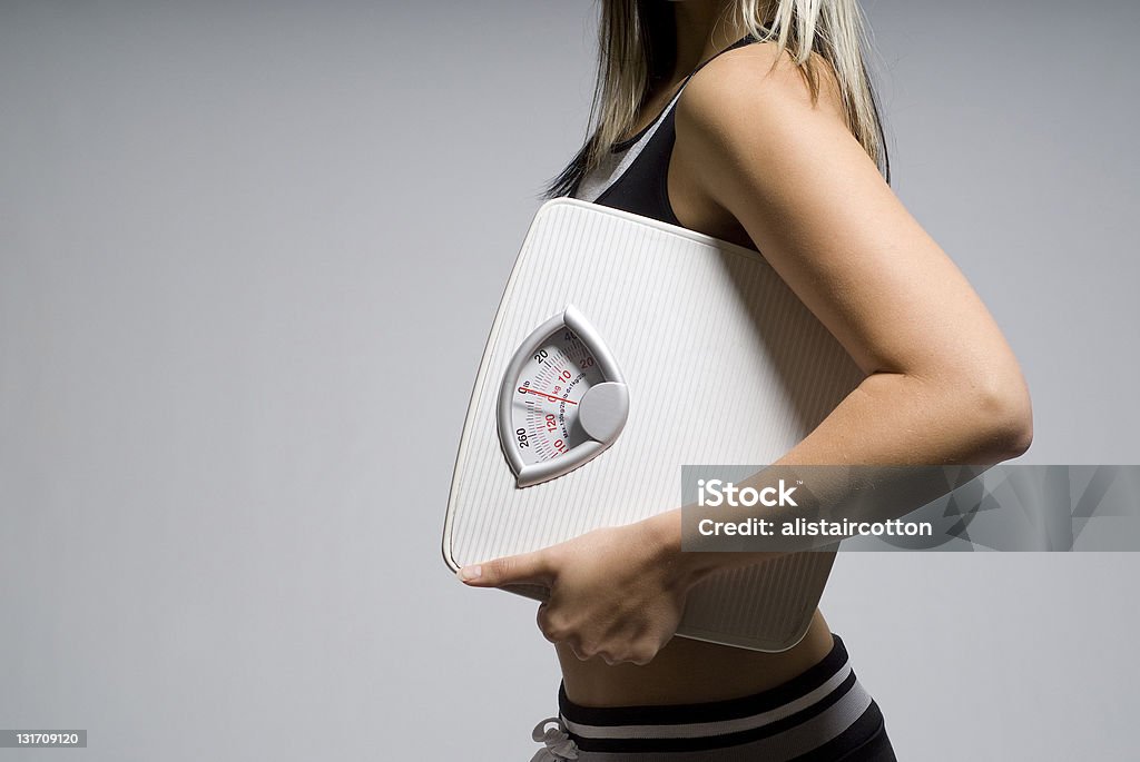 Diet scale and woman Diet or dieting scale concept held by slim, healthy or trim woman Adult Stock Photo