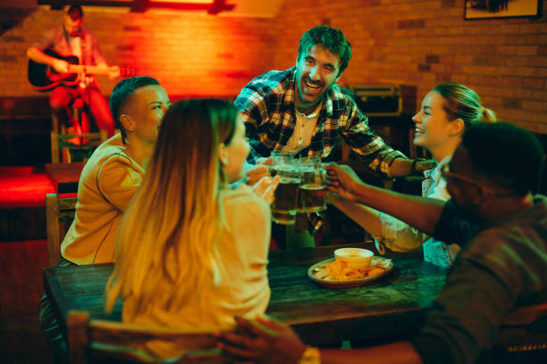 istock Happy friends toasting with beer and having fun while gathering in a bar at night. 1317094536
