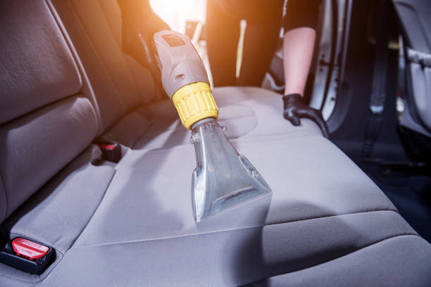 Worker Cleans Car Interior With Vacuum Cleaner Stock Photo