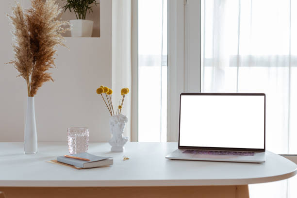 istock Laptop with blank white screen in office desk interior. Stylish workplace mockup. 1317099897