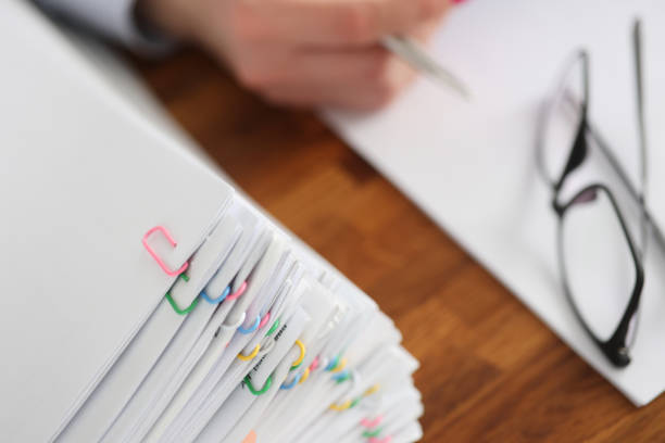 Lot of documents with colored paper clips lying on desktop closeup. Paper work concept