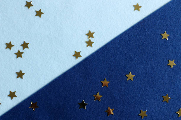 istock Golden stars are scattered on a blue and light blue background 1317103045