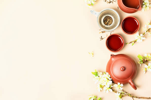 istock Asian Tea set on stone slate board, ceramic teapot, cups, dried tea and spring branches, copy space 1317103118